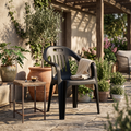 Sillón de jardín de polipropileno negro en uso en una terraza al atardecer