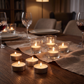 Velas de noche encendidas en sus chapitas sobre una mesa de comedor